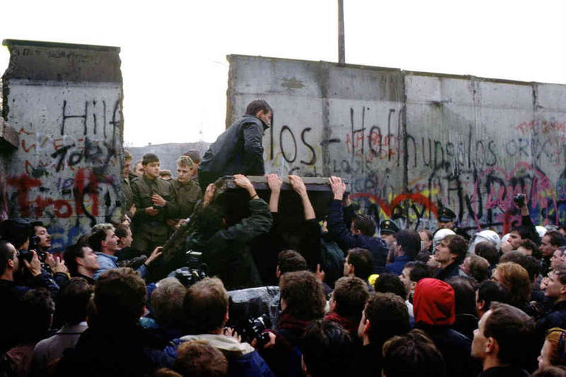 Davy sa zhromažďujú a rúcajú berlínsky múr v novembri 1989.