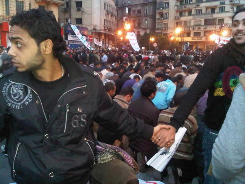 Kresťania a moslimovia zvierajú svoje ruky v solidaritu počas povstania v Káhire. Január 2011.