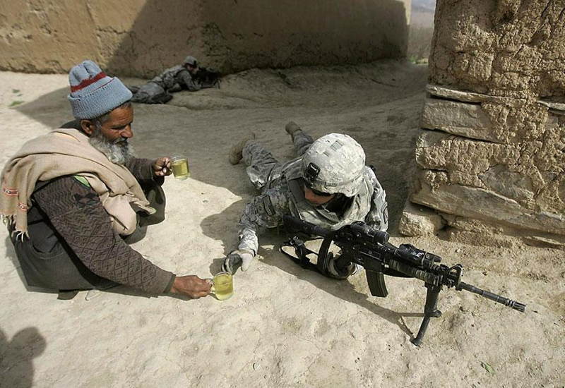 Afgánsky muž ponúka čaj americkému vojakovi pri Kábule. 2009.
