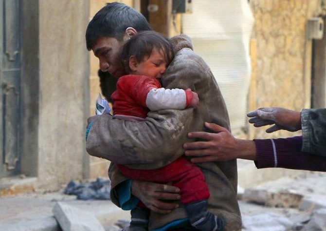 Chlapec zachraňuje svoju sestru z pod trosiek ich dobu v Sýrii.