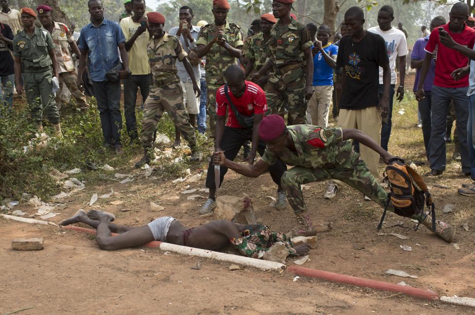 Vojak Africkej armády bodá mŕtvolu muža, ktorý bol zabitý kvôli obvineniu, že sa spriahol so seléckymi bolovníkmi. Bangui 5.2.2014.