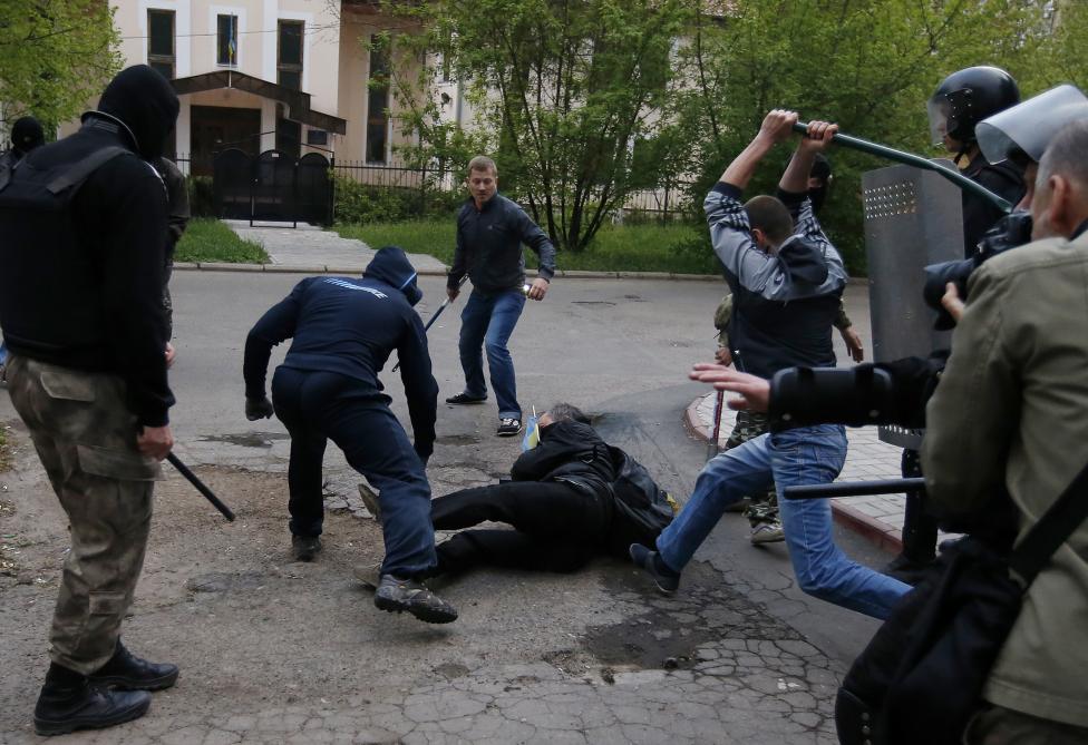 Pro-ruský demonštranti útočia na pro-ukrajinského demonštranta počas demonštrácii v Donecku. 28.4.2014.