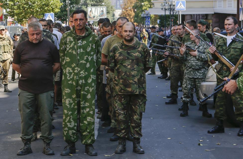 Ozbrojení ruskí separatisti sprevádzajú ukrajinských vojnových zajatcov v Donecku. 24.8.2014.