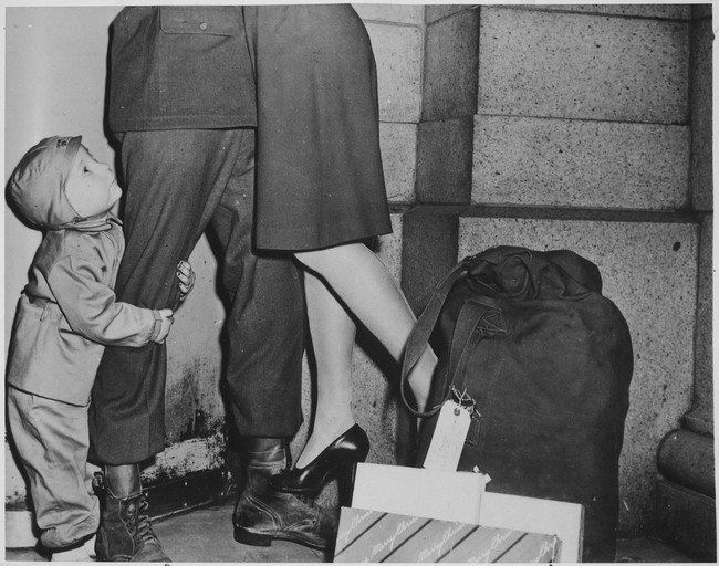 Malý chlapec zviera svojho otca, vojaka, ktorý prišiel na Vianoce domov (1944).