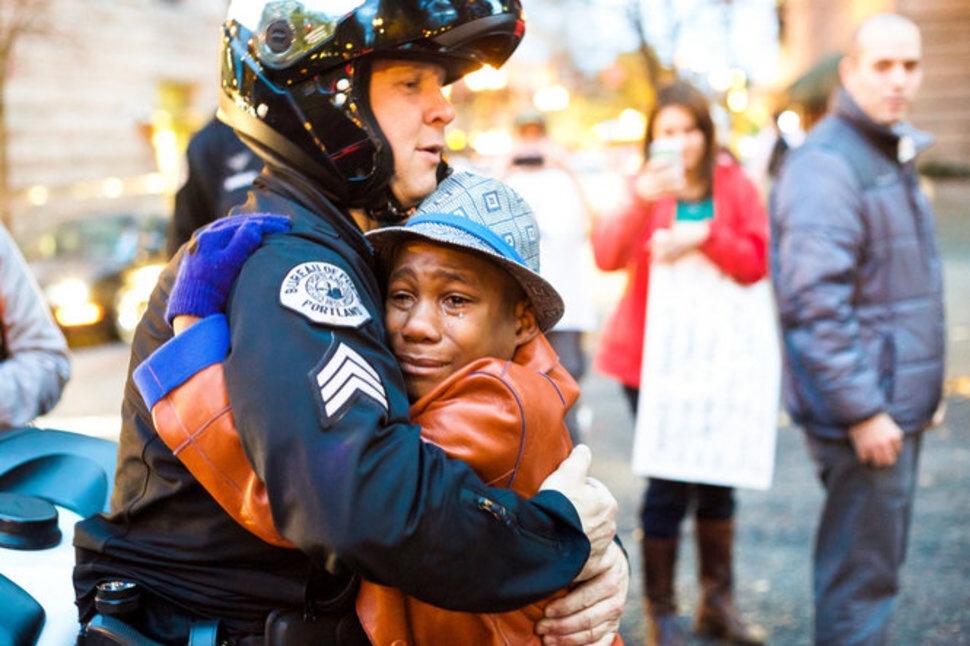  Bret Barnum objíma 12-ročného Devona Harta, po streľbe na Michaela Browna na demonštrácii. November.