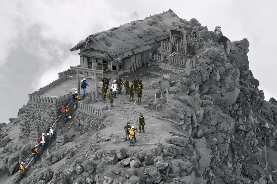 Záchranári vstupujú do popolom pokrytej svätyne v blízkosti vrcholu Mt. Ontake v Japonsku, ktorá vybuchla a zabila 56 ľudí.