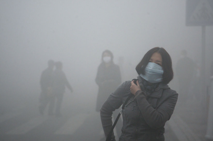 Mladá žena v meste Peking, kde je miera smogu až 40-krát výššia, ako je medzinárodný štandard.