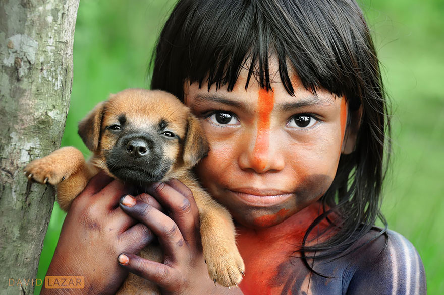 Tradične pomaľované dievčatko si stráži svojho psíka.